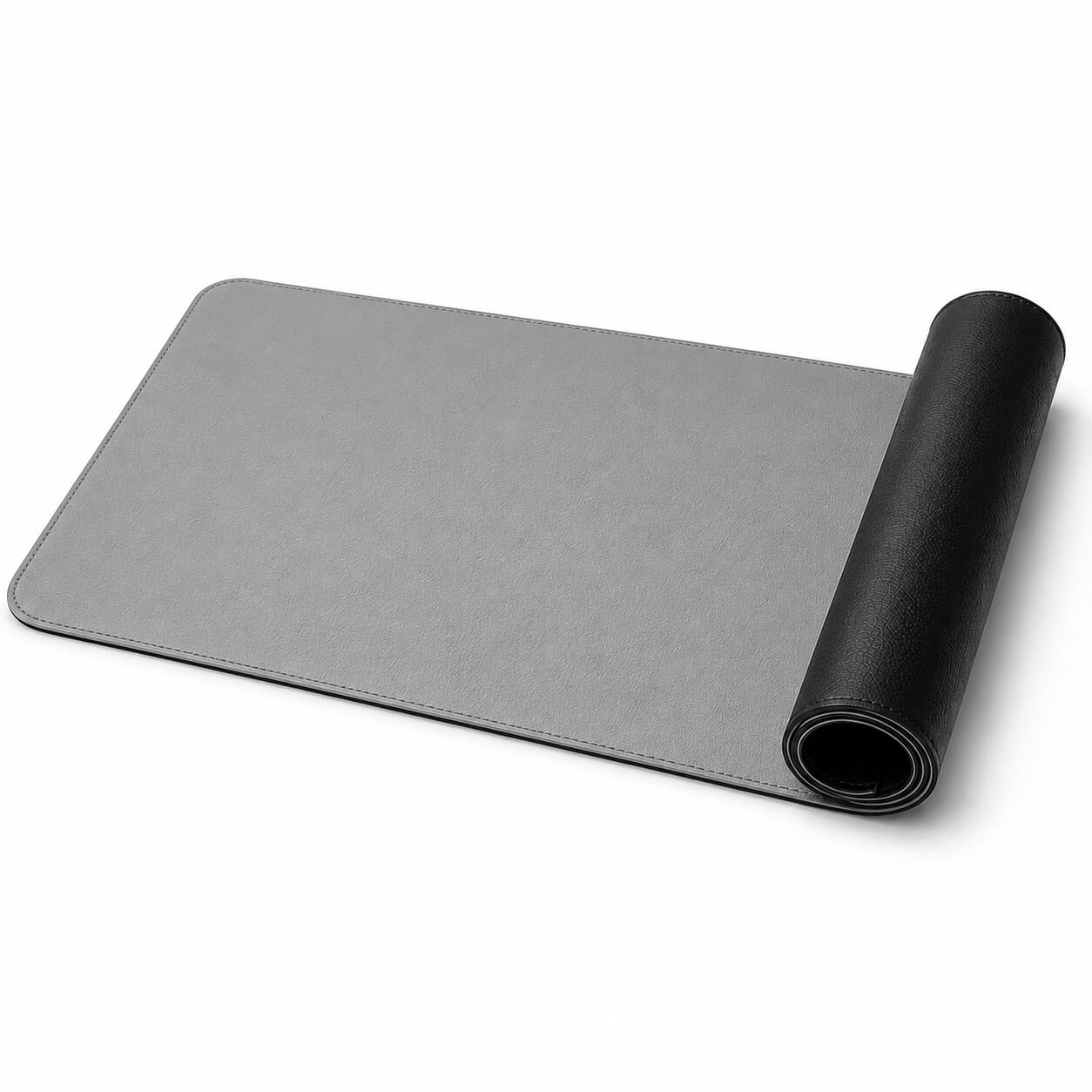 Desdet F50 reversible vegan leather desk mat rolled up showing both midnight black and steel grey sides

