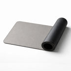 Desdet F50 reversible vegan leather desk mat rolled up showing both midnight black and steel grey sides
